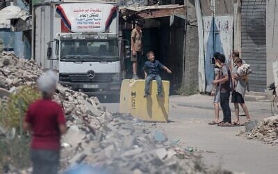 Des enfants gazaouis jouant sur un bloc de béton destiné à marquer la « Ligne jaune » établie par Israël, dans le quartier de Shejaiya, à l'est de Gaza-City, le 26 juillet 2026. (Crédit : Mohammed M. Skaik/JNA Press/Sipa USA via Reuters)