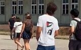 Un adolescent portant un tee-shirt sur lequel semble figurer la terroriste palestinienne Dalal Mughrabi, au mémorial du camp de concentration nazi de Mauthausen, en Autriche. (Crédit : Capture d'écran d'une vidéo X ; utilisée conformément à l'article 27a de la loi sur le droit d'auteur)