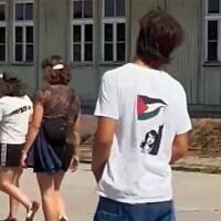 Un adolescent portant un tee-shirt sur lequel semble figurer la terroriste palestinienne Dalal Mughrabi, au mémorial du camp de concentration nazi de Mauthausen, en Autriche. (Crédit : Capture d'écran d'une vidéo X ; utilisée conformément à l'article 27a de la loi sur le droit d'auteur)
