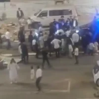Capture d’écran d’une vidéo montrant un groupe de Haredim entourant une voiture de police dans une rue bloquée pour empêcher les automobilistes d’y circuler pendant le shabbat, le 28 août 2026, à Bnei Brak. (Capture d’écran/X)