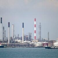 Illustration : un pétrolier (à droite) passe devant des raffineries de pétrole sur l'île de Bukom, au large de Singapour, le 17 mars 2022. (Crédit : Roslan Rahman/AFP)