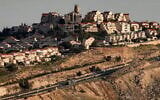 Cette photo, prise depuis la zone E1 au nord-est de Jérusalem, montre des véhicules circulant sur une autoroute près de l'implantation  de Maale Adumim, en Cisjordanie, le 4 février 2026. (Crédit : Ahmad Gharabli/AFP)