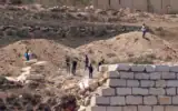 Des résidents d’implantations israéliens se rassemblent devant des maisons palestiniennes dans le village de Qusra, au sud de Naplouse, en Cisjordanie, le 12 août 2026. (Crédit : Zain JAAFAR/AFP)