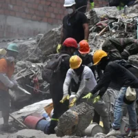 Des équipes de secours et des bénévoles recherchent des survivants parmi les décombres d'un bâtiment effondré suite au séisme survenu à Cali, en Colombie, le 12 août 2026. (Raul ARBOLEDA/AFP)