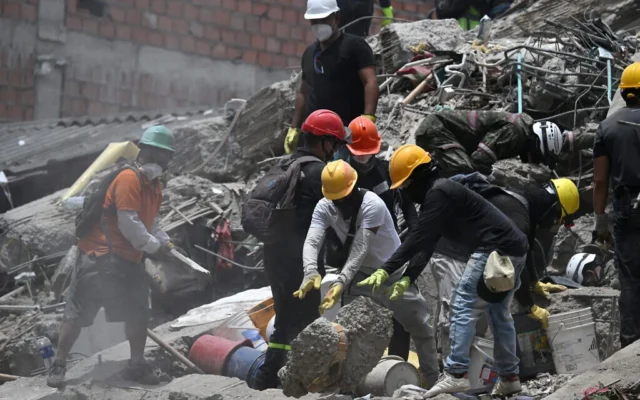 Des équipes de secours et des bénévoles recherchent des survivants parmi les décombres d'un bâtiment effondré suite au séisme survenu à Cali, en Colombie, le 12 août 2026. (Raul ARBOLEDA/AFP)