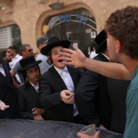 Des manifestants ultra-orthodoxes protestent contre l'ouverture du Café Basimta le shabbat, jour de repos hebdomadaire juif, tandis que des militants laïques organisent une contre-manifestation en soutien au café, dans le centre de Jérusalem, le 15 août 2026. (Crédit: AHMAD GHARABLI/AFP)