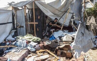 Des Gazaouis inspectant les dégâts sur le site d'une frappe israélienne présumée contre une tente, à Khan Younès, dans le sud de la bande de Gaza, le 16 août 2026. (Crédit : Bashar Taleb/AFP)