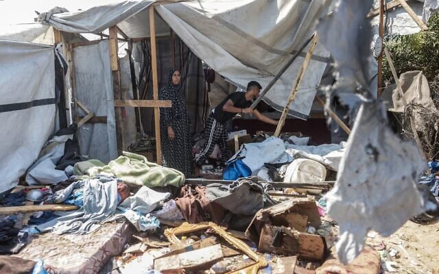 Des Gazaouis inspectant les dégâts sur le site d'une frappe israélienne présumée contre une tente, à Khan Younès, dans le sud de la bande de Gaza, le 16 août 2026. (Crédit : Bashar Taleb/AFP)