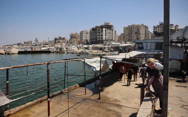 Des Palestiniens sur un site du port de la ville de Gaza qui a été pris pour cible par une frappe de l’armée israélienne la veille, le 19 août 2026. (Omar AL-QATTAA/AFP)