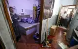 La femme de Fathi Khazem, 58 ans, tué alors qu'il tentait de poignarder un soldat lors d'une interpellation, se tient devant la porte de sa chambre près d'une flaque de son sang au domicile familial à Jénine, dans le nord de la Cisjordanie, le 21 août 2026. (Jaafar Ashtiyeh/AFP)