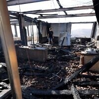 Un Palestinien inspectant l'un des bâtiments de sa propriété, qui aurait été incendié et tagué par des résidents d'implantation israéliens au sud de Naplouse, en Cisjordanie, le 23 août 2026. (Crédit : Jaafar Ashtiyeh/AFP)