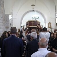 Des pleureurs portant le cercueil de l'artiste palestinien Sliman Mansour lors de ses funérailles à l'église épiscopale Saint-Pierre, dans la ville de Birzeit, au nord de Ramallah, en Cisjordanie, le 26 août 2026. (Crédit : Zain Jaafar/AFP)