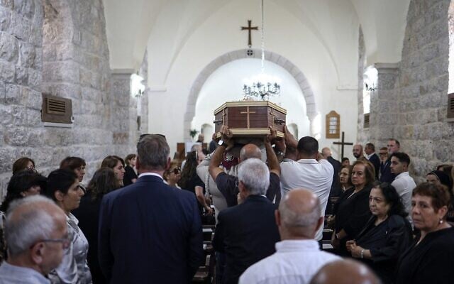 Des pleureurs portant le cercueil de l'artiste palestinien Sliman Mansour lors de ses funérailles à l'église épiscopale Saint-Pierre, dans la ville de Birzeit, au nord de Ramallah, en Cisjordanie, le 26 août 2026. (Crédit : Zain Jaafar/AFP)