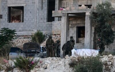 Des soldats israéliens évacuant le corps d'un Palestinien tué lors d'une frappe aérienne d'une maison en construction, dans la banlieue ouest de la ville de Jénine, au nord de la Cisjordanie, le 28 août 2026. (Crédit : Jaafar Ashtiyeh/AFP) Des soldats israéliens évacuant le corps d'un Palestinien tué lors d'une frappe aérienne d'une maison en construction, dans la banlieue ouest de la ville de Jénine, au nord de la Cisjordanie, le 28 août 2026. (Crédit : Jaafar Ashtiyeh/AFP)