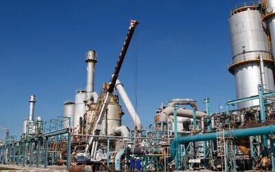 Des ouvriers marocains se tiennent devant l'unité industrielle d'une nouvelle production d'acide phosphorique et d'engrais phosphaté à Jorf Lasfar, près d'El Jadida, au Maroc, le jeudi 22 décembre 2011. De loin, la région possédant les plus importantes réserves de phosphate est le Maroc et le Sahara occidental en Afrique, avec des réserves estimées à 21 milliards de tonnes, tandis que les réserves totales des États-Unis sont plus modestes, à 4,6 milliards de tonnes. (Crédit : Abdeljalil Bounhar/AP) Des ouvriers marocains se tiennent devant l'unité industrielle d'une nouvelle production d'acide phosphorique et d'engrais phosphaté à Jorf Lasfar, près d'El Jadida, au Maroc, le jeudi 22 décembre 2011. De loin, la région possédant les plus importantes réserves de phosphate est le Maroc et le Sahara occidental en Afrique, avec des réserves estimées à 21 milliards de tonnes, tandis que les réserves totales des États-Unis sont plus modestes, à 4,6 milliards de tonnes. (Crédit : Abdeljalil Bounhar/AP)