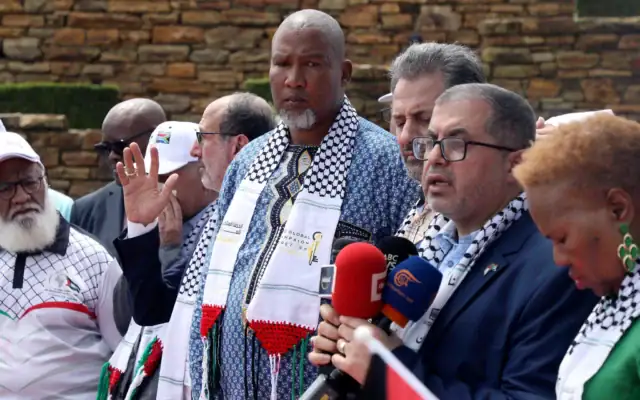 Basem Naim, responsable du Hamas (deuxième à droite), s’adresse à un journaliste, sous le regard de Mandla Mandela (au centre), petit-fils de Nelson Mandela, lors d’une marche marquant le 10ᵉ anniversaire de la mort de l’ancien président sud-africain, à Pretoria, en Afrique du Sud, le 5 décembre 2023. (Crédit : AP)