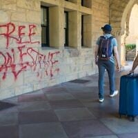 Des étudiants passant devant des graffitis près du bureau du président de l’université de Stanford, Richard Saller, à Palo Alto, en Californie, le 5 juin 2024. (Crédit : Nic Coury/AP)