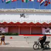 Des festivaliers foulant le tapis rouge du Festival du film de Venise, lors de sa 81ᵉ édition, à Venise, en Italie, le 27 août 2024. (Crédit : Vianney Le Caer/Invision/AP)