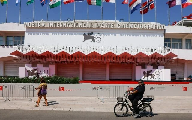 Des festivaliers foulant le tapis rouge du Festival du film de Venise, lors de sa 81ᵉ édition, à Venise, en Italie, le 27 août 2024. (Crédit : Vianney Le Caer/Invision/AP)