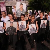 Les proches des pompiers tués lors de l'explosion du port de Beyrouth en 2020 brandissent leurs portraits, alors qu'ils défilent lors d'une cérémonie commémorative marquant le sixième anniversaire de cette gigantesque explosion à Beyrouth, au Liban, le mardi 4 août 2026. (Crédit : AP Photo/Hussein Malla)