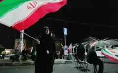 Une femme agite un drapeau iranien lors d’un rassemblement pro-gouvernemental sur une place de Téhéran, en Iran, le 11 août 2026. (Crédit : AP)