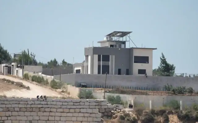 Des résidents d'implantations israéliennes se rassemblent devant les maisons palestiniennes qu’ils assiègent dans le village de Qusra, en Cisjordanie, au sud de Naplouse, le 13 août 2026. (AP/Majdi Mohammed)