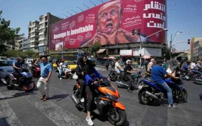Des motards passant devant un panneau publicitaire représentant le président américain Donald Trump, les mains autour du cou, sous l’inscription "La vengeance est inévitable", à Téhéran, en Iran, le 24 août 2026. (Crédit : Vahid Salemi/AP) Des motards passant devant un panneau publicitaire représentant le président américain Donald Trump, les mains autour du cou, sous l’inscription "La vengeance est inévitable", à Téhéran, en Iran, le 24 août 2026. (Crédit : Vahid Salemi/AP)