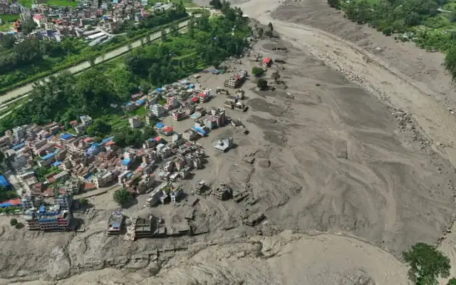 Des maisons endommagées au bord de la rivière Trishuli, en crue et charriant des débris, après les inondations soudaines qui ont frappé le district de Nuwakot, au Népal, le 26 août 2026. (Crédit : Niranjan Shrestha/AP)