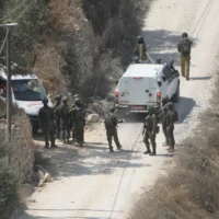Des soldats de l’armée israélienne sécurisant un bâtiment en construction tandis que des ambulances évacuent des Palestiniens blessés à la suite d’une attaque perpétrée par des partisans du mouvement pro-implantations, dans le village de Qusra, en Cisjordanie, le 29 août 2026. (Crédit : Majdi Mohammed/AP)