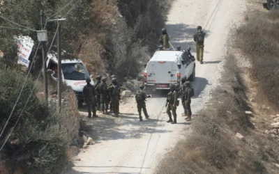 Des soldats de l’armée israélienne sécurisant un bâtiment en construction tandis que des ambulances évacuent des Palestiniens blessés à la suite d’une attaque perpétrée par des partisans du mouvement pro-implantations, dans le village de Qusra, en Cisjordanie, le 29 août 2026. (Crédit : Majdi Mohammed/AP)