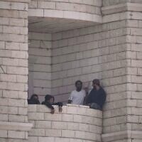 Des résidents d'implantation ayant attaqué un village palestinien sur le balcon d'un immeuble en construction, à Qusra, en Cisjordanie, le 29 août 2026. (Crédit : Majdi Mohammed/AP)