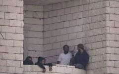 Des résidents d'implantation ayant attaqué un village palestinien sur le balcon d'un immeuble en construction, à Qusra, en Cisjordanie, le 29 août 2026. (Crédit : Majdi Mohammed/AP)