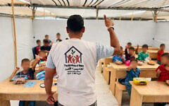 Un enseignant faisant cours à des enfants du Gaza Children’s Village (GCV), dans le camp d'al-Mawasi. (Crédit : Autorisation)