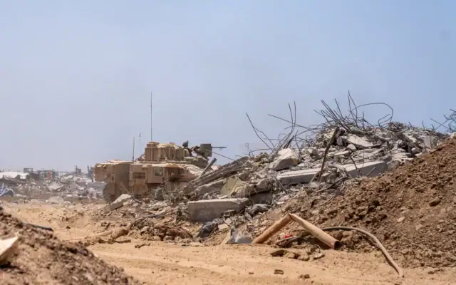 Illustration : Des soldats de la brigade Givati tirant depuis un véhicule blindé de transport de troupes Namer, à Beit Hanoun, au nord de Gaza, le 30 juillet 2025. (Crédit : Emanuel Fabian/Times of Israel)
