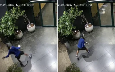 Un homme masqué filmé par une caméra de surveillance alors qu’il lance une brique contre les portes vitrées des bureaux de la chaîne N12 à Tel Aviv, aux premières heures du 28 juillet 2026. (Crédit : N12/X)