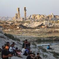 Des Palestiniens près de bâtiments détruits lors de la récente guerre entre Israël et le Hamas, à Gaza-City, au centre de la bande de Gaza, le 31 juillet 2026. (Crédit : Ali Hassan/Flash90)