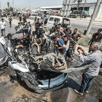 Des Gazaouis rassemblés sur les lieux d'une frappe israélienne visant un véhicule dans la rue Salah al-Din, à Deir al-Balah, au centre de la bande de Gaza, le 2 août 2026. (Crédit : Ali Hassan/Flash90)