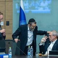 Le député Hanoch Milwidsky, président de la commission des Finances (à droite), s'entretenant avec les députés Moshe Gafni (au centre) et Yitzhak Pindrus lors d'une réunion de la commission des Finances de la Knesset, à Jérusalem, le 4 août 2026. (Crédit : Chaïm Goldberg/Flash90)