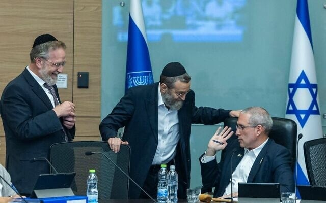Le député Hanoch Milwidsky, président de la commission des Finances (à droite), s'entretenant avec les députés Moshe Gafni (au centre) et Yitzhak Pindrus lors d'une réunion de la commission des Finances de la Knesset, à Jérusalem, le 4 août 2026. (Crédit : Chaïm Goldberg/Flash90)