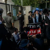 Des manifestants ultra-orthodoxes protestant contre une réunion d'information sur le recrutement dans l'armée israélienne destinée à la communauté haredi, à Jérusalem, le 4 août 2026. (Crédit : Chaïm Goldberg/Flash90)