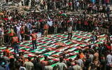 Des Gazaouis accomplissant les rites funéraires lors des funérailles collectives des personnes qui auraient été tuées lors d'une frappe israélienne en novembre 2023, à Gaza-City, le 4 août 2026. (Crédit : Fathi Ibrahim/Flash90)
