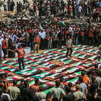 Des Gazaouis accomplissant les rites funéraires lors des funérailles collectives des personnes qui auraient été tuées lors d'une frappe israélienne en novembre 2023, à Gaza-City, le 4 août 2026. (Crédit : Fathi Ibrahim/Flash90)