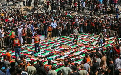 Des Gazaouis accomplissant les rites funéraires lors des funérailles collectives des personnes qui auraient été tuées lors d'une frappe israélienne en novembre 2023, à Gaza-City, le 4 août 2026. (Crédit : Fathi Ibrahim/Flash90)