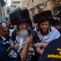 Des manifestants ultra-orthodoxes protestant contre un café ouvert pendant Shabbat, en confrontation avec la police israélienne, dans le centre-ville de Jérusalem, le 8 août 2026. (Crédit : Oren Ben Hakoon/Flash90)