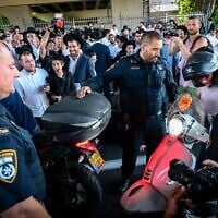 Des Juifs ultra-orthodoxes affrontant la police lors d’une manifestation contre l’enrôlement des Haredim dans l’armée israélienne, sur la Route 4 près de Bnei Brak, le 8 août 2026. (Crédit : Avshalom Sassoni/Flash90)