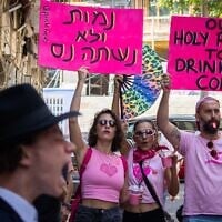 Des militants laïcs brandissant des pancartes lors d'une contre-manifestation contre des hommes haredim au Café Basimta, à Jérusalem, le 15 août 2026. L'inscription en hébreu dit : « Nous préférerions mourir plutôt que de boire du café instantané », un jeu de mots sur un slogan utilisé par les ultra-orthodoxes opposés à la conscription dans l'armée. (Crédit : Oren Ben Hakoon/Flash90)