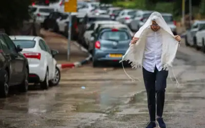 Un homme marchant sous la pluie, à Jérusalem, le 15 août 2026. (Crédit : Yossi Zamir/Flash90)