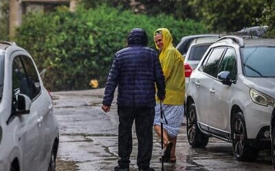 Des passants marchant sous la pluie, à Jérusalem, le 15 août 2026. (Crédit : Yossi Zamir/Flash90)