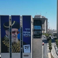 Le leader spirituel de Shas, le Grand Rabbin Yitzhak Yosef, et le slogan « J'ai choisi le chemin de la foi », sur une affiche de campagne du parti, à l'entrée de Jérusalem, le 20 août 2026. (Crédit : Chaïm Goldberg/Flash90)