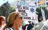 Une femme frappe sur une casserole à côté d'une pancarte disant « Le sionisme n'est pas encore mort, et nous ne savons pas quand il le sera », lors d'un rassemblement pro-palestinien et anti-Israël à Podgorica, au Monténégro, le 14 septembre 2025. (Photo de SAVO PRELEVIC / AFP)